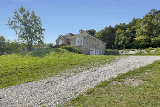 view of side of property featuring a yard and a garage