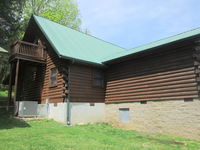 view of property exterior featuring central AC unit, a balcony, and a yard