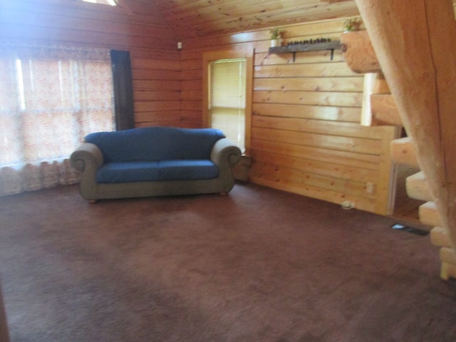 sitting room with wooden ceiling, wood walls, dark colored carpet, and vaulted ceiling