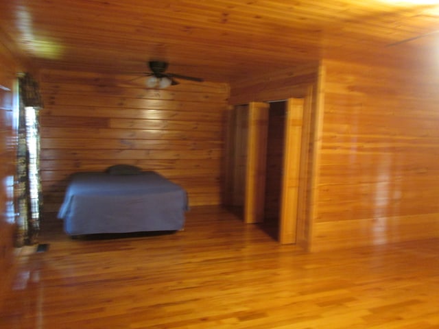 unfurnished bedroom with wood ceiling, light hardwood / wood-style floors, and wooden walls