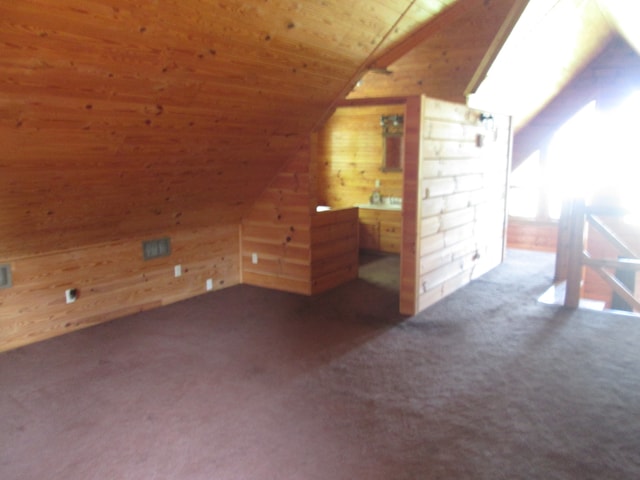 bonus room with wooden ceiling, wooden walls, vaulted ceiling, and dark colored carpet