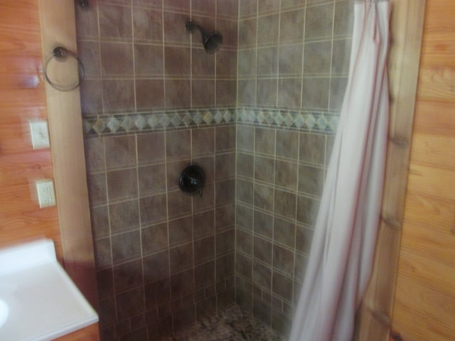 bathroom featuring walk in shower and wooden walls