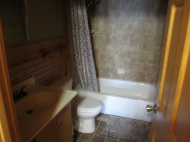 full bathroom featuring vanity, toilet, tile floors, and shower / bath combo with shower curtain