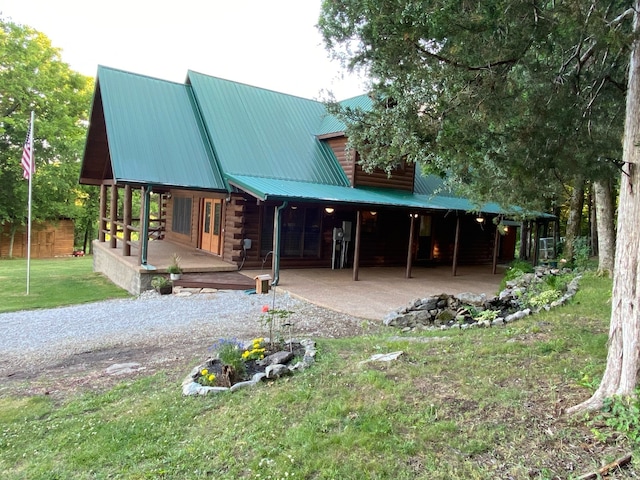 back of property with covered porch and a lawn