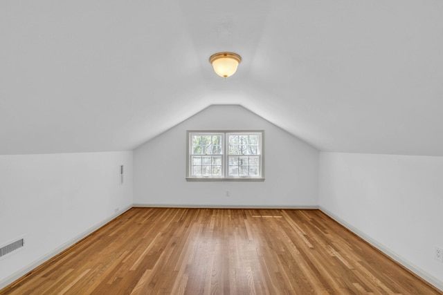 bonus room with vaulted ceiling and light hardwood / wood-style floors