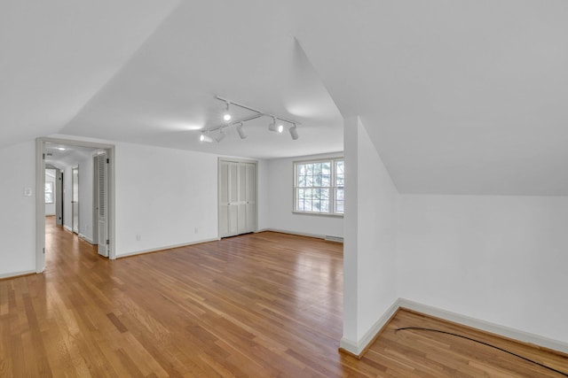 bonus room featuring light wood-type flooring and vaulted ceiling