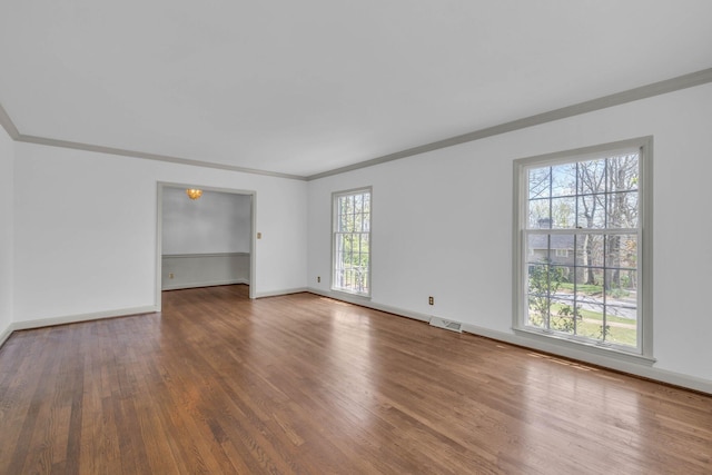 empty room with wood-type flooring and ornamental molding