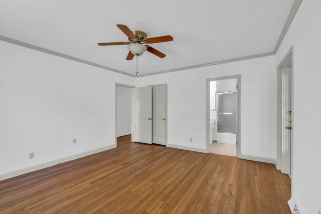 unfurnished bedroom featuring a closet, crown molding, ceiling fan, hardwood / wood-style floors, and ensuite bath