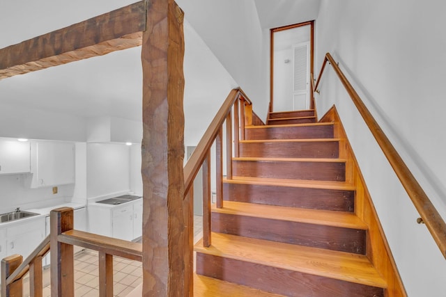 staircase featuring sink and hardwood / wood-style floors