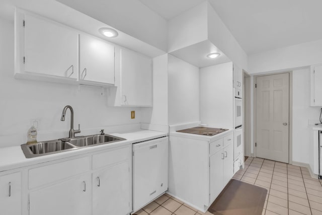 kitchen with light tile patterned floors, white dishwasher, sink, and white cabinetry