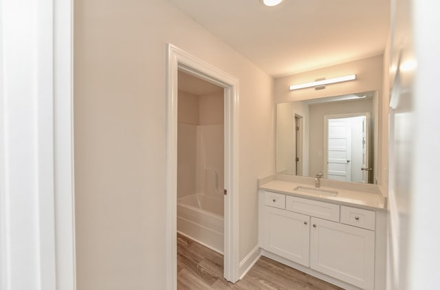 bathroom featuring vanity, tub / shower combination, and hardwood / wood-style floors