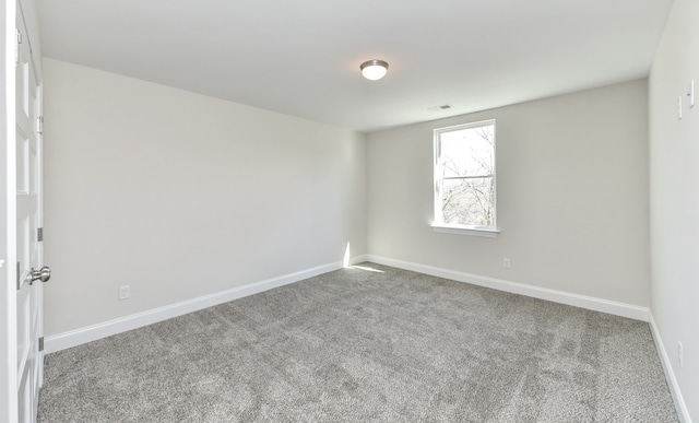 spare room featuring light carpet