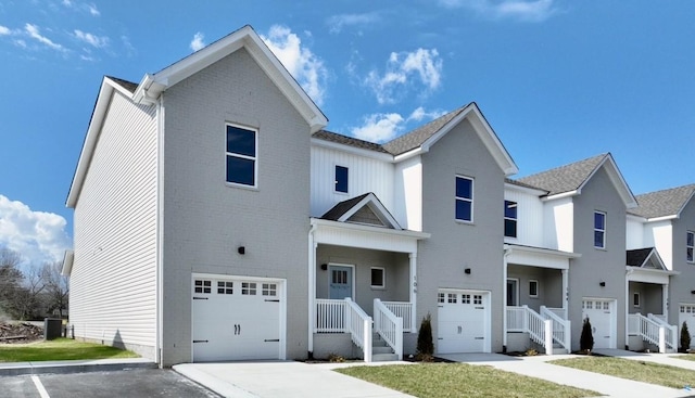 townhome / multi-family property featuring central air condition unit and a garage