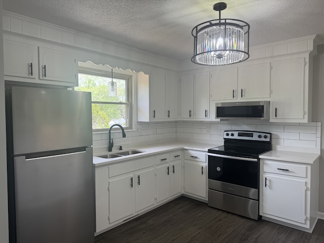 kitchen with sink, white cabinetry, dark wood-type flooring, a chandelier, and stainless steel appliances