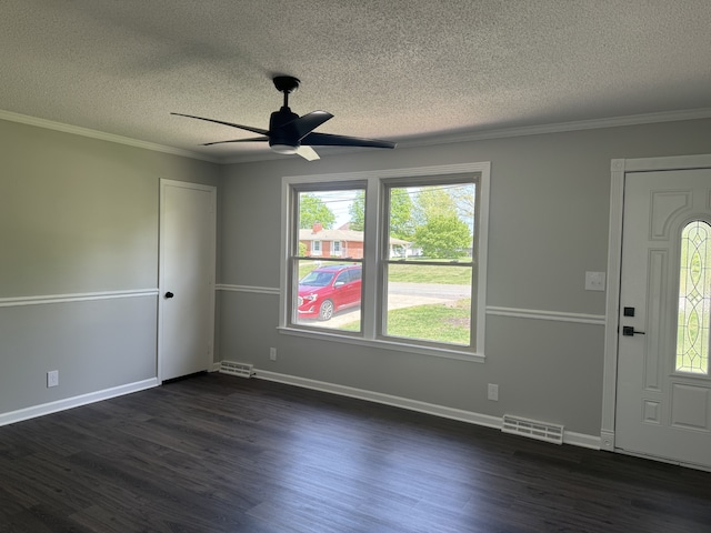 entryway with a textured ceiling, ceiling fan, ornamental molding, and dark wood-type flooring