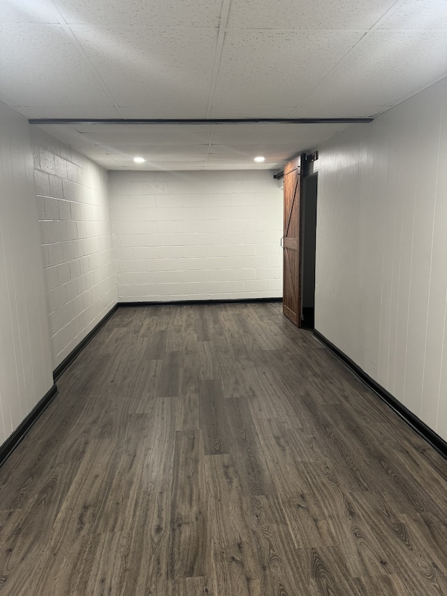 spare room featuring a paneled ceiling, a barn door, and dark hardwood / wood-style floors