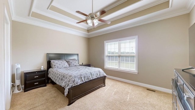 bedroom with a raised ceiling, light carpet, ceiling fan, and ornamental molding