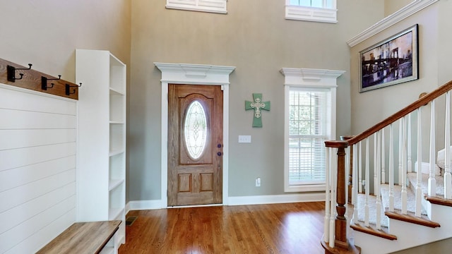 entryway featuring plenty of natural light, wood-type flooring, and a towering ceiling