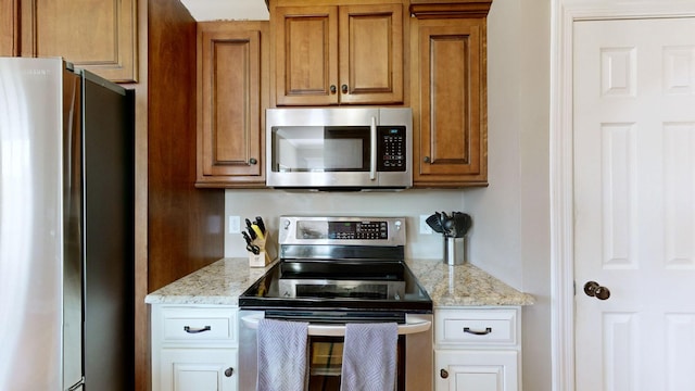 kitchen featuring appliances with stainless steel finishes and light stone countertops