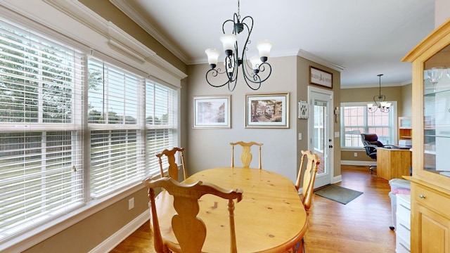 dining area featuring light hardwood / wood-style flooring, a chandelier, and ornamental molding