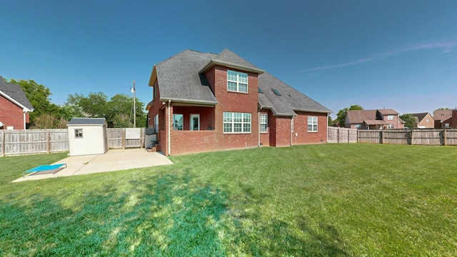 back of house featuring a storage unit, a lawn, and a patio area