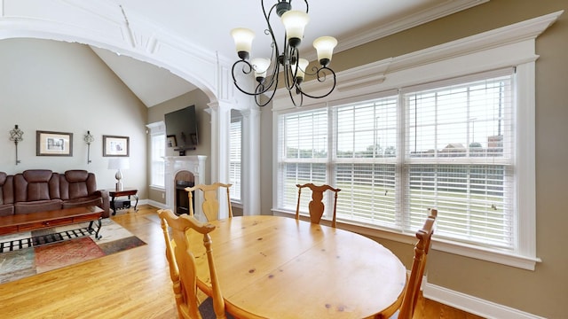 dining room with lofted ceiling, ornamental molding, an inviting chandelier, and hardwood / wood-style floors