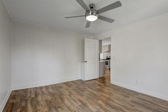 spare room with wood-type flooring, ceiling fan, and ornamental molding