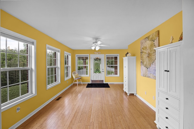 unfurnished sunroom with ceiling fan