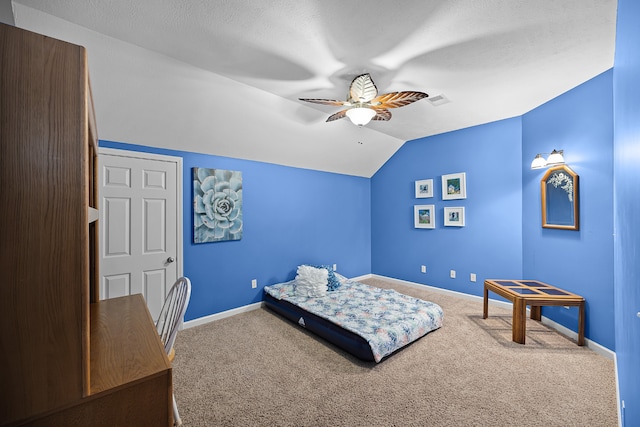 carpeted bedroom with vaulted ceiling, ceiling fan, and a textured ceiling