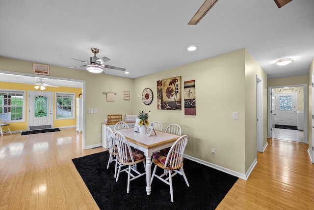 dining space with ceiling fan and light hardwood / wood-style flooring