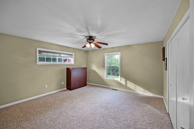 unfurnished bedroom featuring light colored carpet and ceiling fan