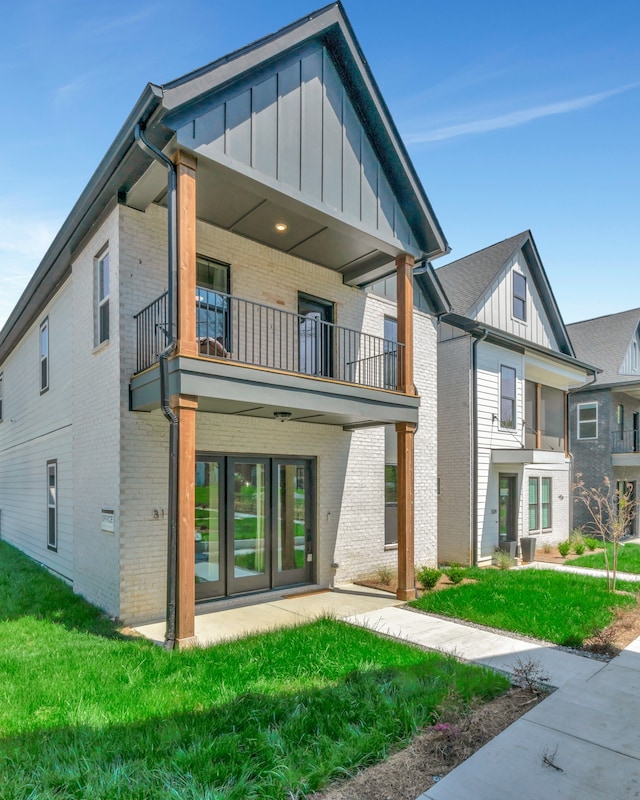 exterior space featuring french doors, a yard, and a balcony