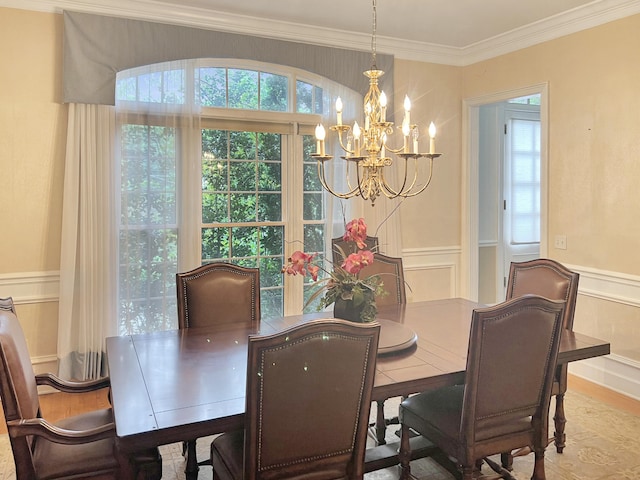 dining space with crown molding, hardwood / wood-style floors, and a notable chandelier