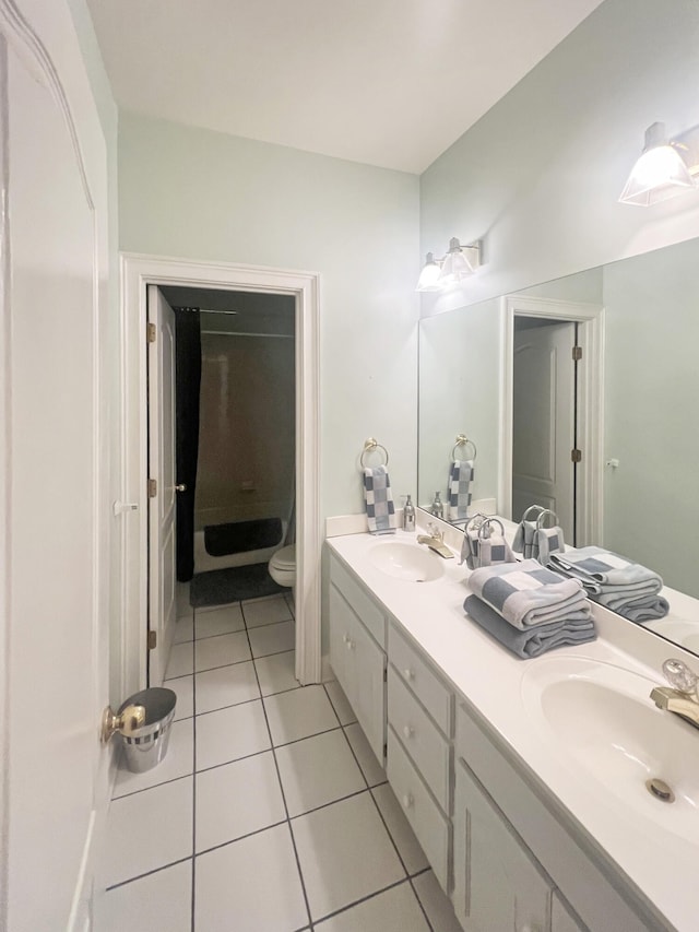 bathroom featuring toilet, tile floors, and dual vanity