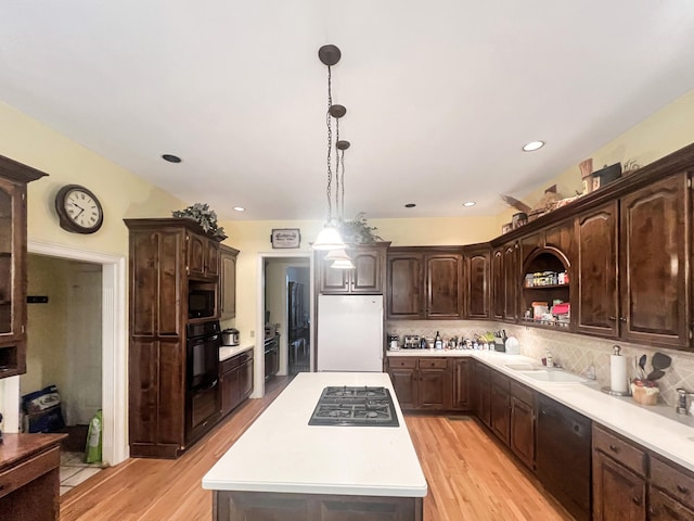 kitchen with dark brown cabinetry, light hardwood / wood-style flooring, a kitchen island, and black appliances