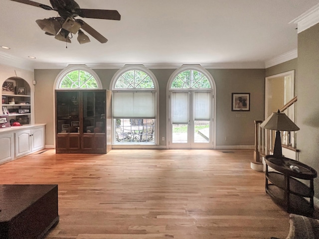 living room with light hardwood / wood-style flooring, ceiling fan, and crown molding