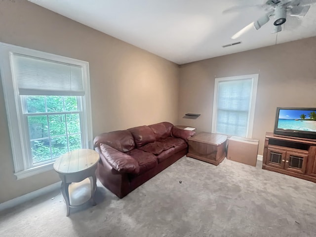 carpeted living room with ceiling fan