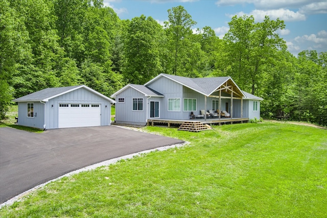 ranch-style home featuring an outbuilding, a garage, covered porch, and a front lawn