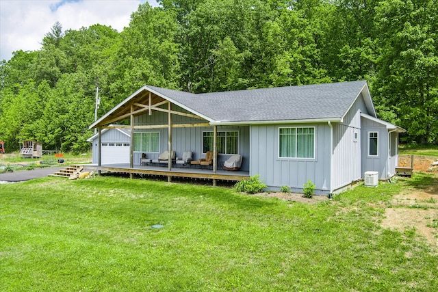 single story home with a wooden deck, a front lawn, and central air condition unit