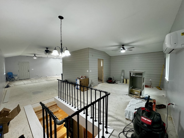 interior space featuring ceiling fan with notable chandelier, lofted ceiling, and a wall unit AC