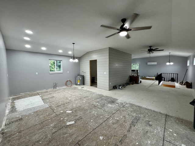 interior space with lofted ceiling, a fireplace, water heater, ceiling fan with notable chandelier, and a wall mounted air conditioner