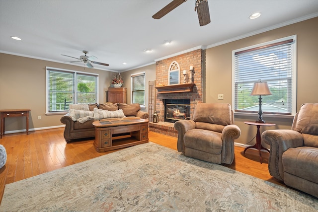 living room with ceiling fan, light wood-type flooring, a fireplace, and a wealth of natural light