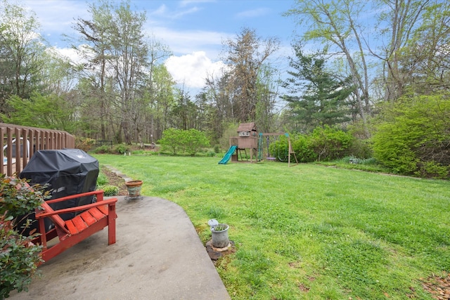 view of yard featuring a playground and a patio