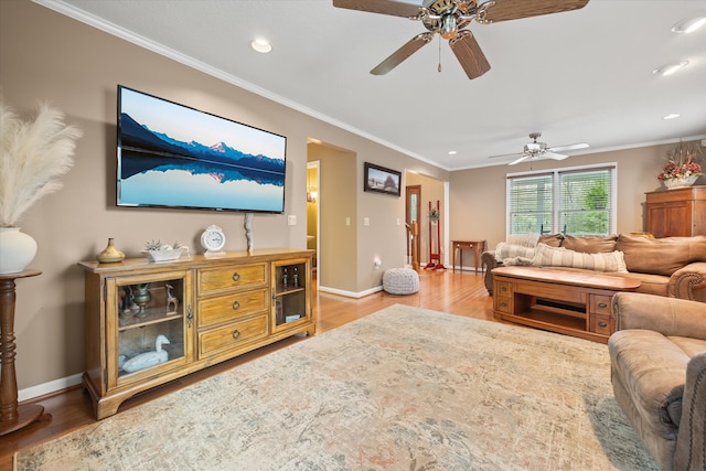 living room with ornamental molding, light hardwood / wood-style floors, and ceiling fan