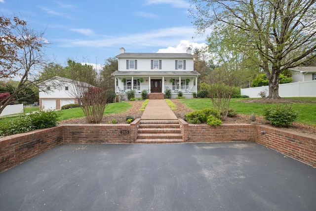 colonial home with covered porch and a garage