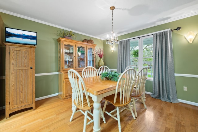 dining area featuring an inviting chandelier, light hardwood / wood-style floors, and crown molding