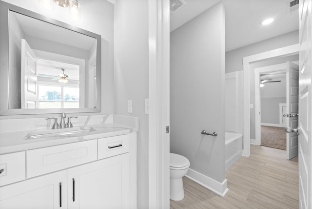 full bathroom featuring visible vents, a washtub, toilet, and vanity