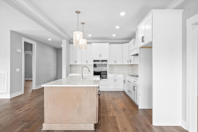 kitchen featuring light stone countertops, dark wood-type flooring, double oven, black electric stovetop, and tasteful backsplash