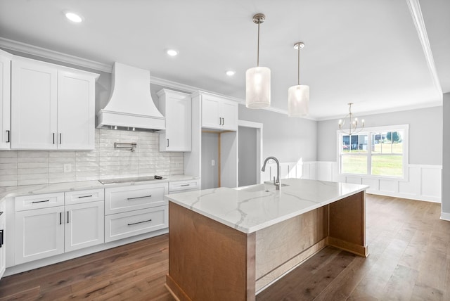 kitchen with black electric cooktop, dark wood finished floors, wainscoting, and custom range hood