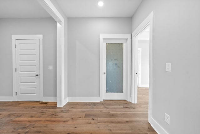 corridor with wood finished floors and baseboards